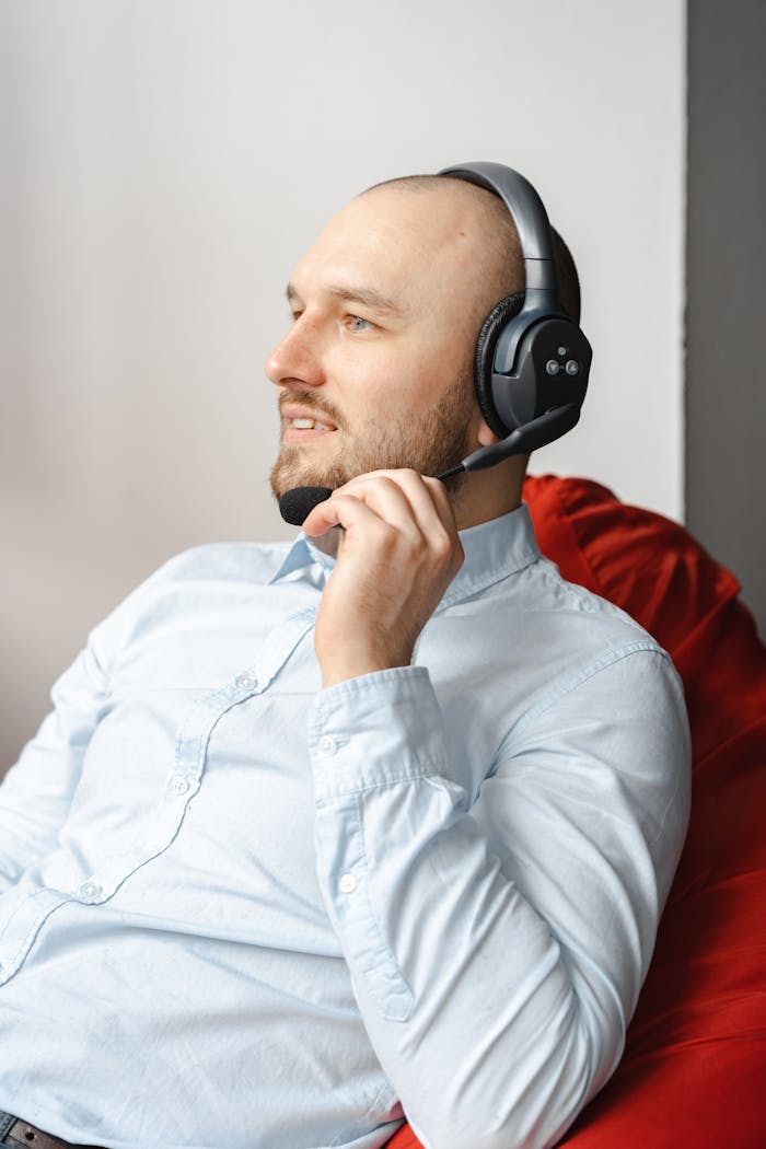 Man in a call center setting wearing a headset, engaged in conversation.